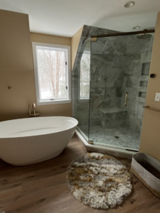 Luxury bathroom remodel featuring a freestanding soaking tub, custom wood vanity cabinetry, marble countertops, and spa-inspired design for increased bathroom remodeling ROI.