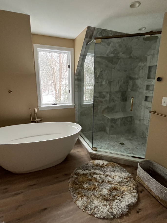 Luxury bathroom remodel featuring a freestanding soaking tub, custom wood vanity cabinetry, marble countertops, and spa-inspired design for increased bathroom remodeling ROI.