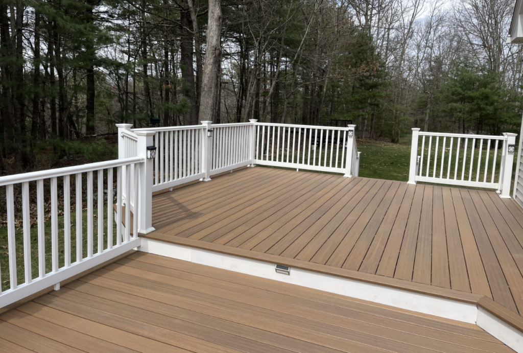 Custom composite deck built by Apple Wood Construction, featuring white railings and multi-level outdoor living space in Londonderry, NH.